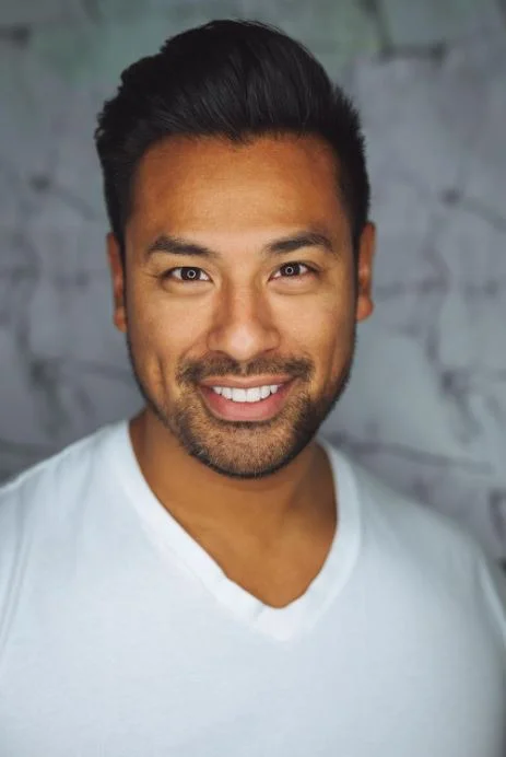 A man smiling for a portrait, showing off his healthy, bright smile